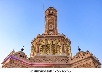 Izmir clock tower low angle architectural detail against blue sky.