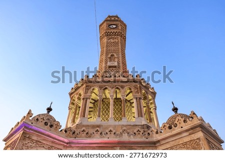 Izmir clock tower low angle architectural detail against blue sky.