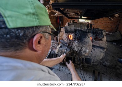 Izmir Kemalpasa Turkey
04-20-2022
Nazarköy Turkey's Evil Eye Boncygy Manufacturing Center. Old Man Sitting In Front Of Bead Oven Making Beads