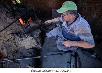 Izmir Kemalpasa Turkey
04-20-2022
Nazarköy Turkey's Evil Eye Boncygy Manufacturing Center. Old Man Sitting In Front Of Bead Oven Making Beads