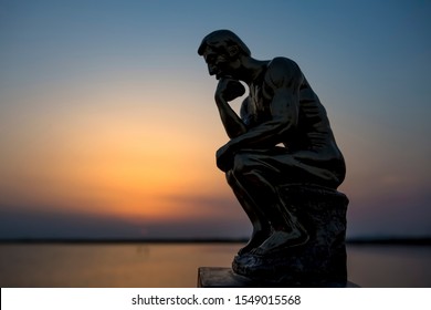 Izmir / Turkey, Auguts 20, 2019, Sculpture thinking man in sunset silhouette. 