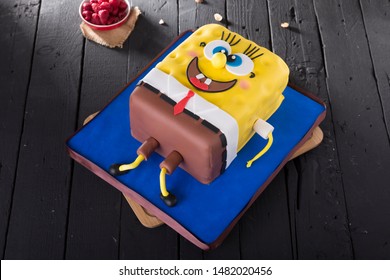 IZMIR, TURKEY - FEBRUARY 10, 2019: Sponge Bob Square Pants Shape Cake on wood table background.
