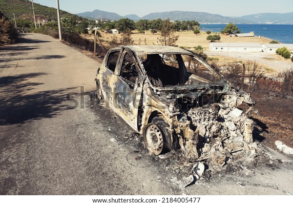 Izmir, Turkey - July\
23, 2022: Burnt car aftermath the forest fire at Derya Site\
Seferihisar Izmir\
Turkey.