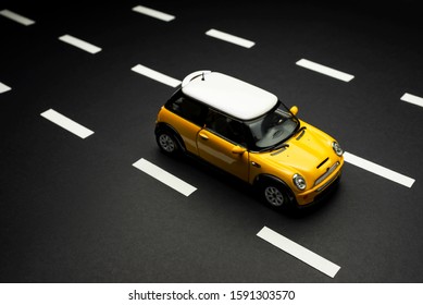 Izmir, Turkey - July 28, 2019. Top Upper View Of A Yellow Mini Cooper S Toy Car On Yellow Background.