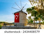 Izmir-Cesme-Turkey: Alacati Windmills, stone structures dating back to the 1850s with Turkish flags hanging, can be visited.  