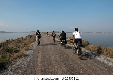 izmir,turkey-03.03.2021: A group of  young people biking on the road in the middle of the water