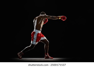 Jab punch. muscular shirtless man, boxer in red uniform practicing before match, training with intensity isolated on black background. Concept of professional sport, active lifestyle, body, strength - Powered by Shutterstock