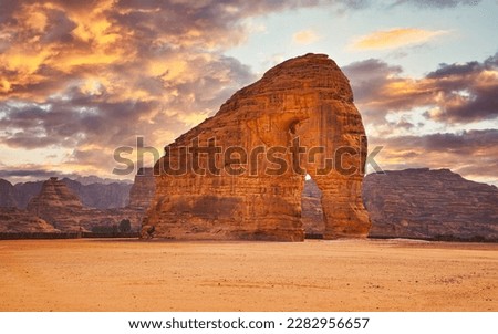 Jabal AlFil - Elephant Rock in Al Ula desert landscape, dramatic sunset sky above - Saudi Arabia