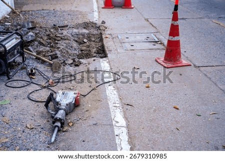 Jack hammer machine placed on concrete road waiting for worker demolish repair concrete floor. Surface road construction by drilling cement ground.