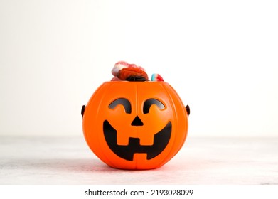 Jack O' Lantern candy bowl full of halloween treats. Trick or treat concept. Copyspace banner