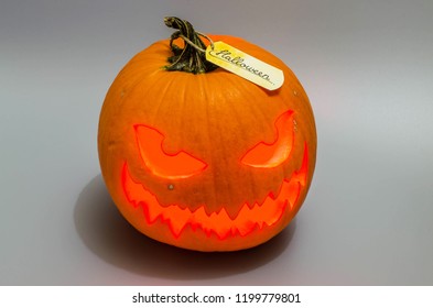 Jack o lantern with red light and label on grey background. Halloween decor.