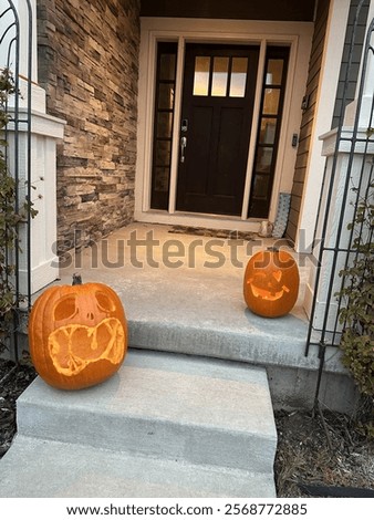 jack o latern pumpkins outside front door on step