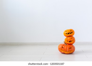 Jack-o-lantern Carved Pumpkin On Light Wall Background With Copy Space, Autumn And Halloween Home Decor