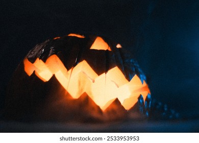 A jack-o'-lantern with a glowing face sits in a dark, smoky room lit by a blue light. - Powered by Shutterstock