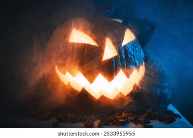 A jack-o'-lantern with a glowing face sits in a dark, smoky room lit by a blue light. - Powered by Shutterstock