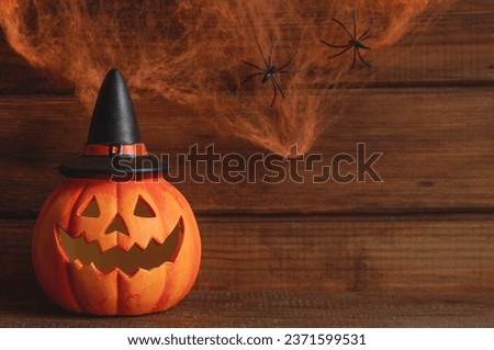 Jack-o-latern against the background of cobweb with two spiders. Halloween postcard. Selective focus, copy space for text