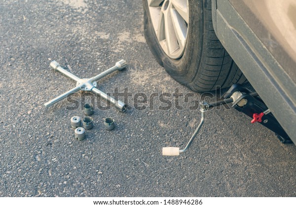 jack-screw, cross wrench and bolts for\
changing of punctured wheel. Hole in the tire.\
Concept