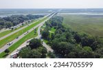 Jackson County Rest Area West rest area with Pascagoula River bridge, large parking lots semi-trucks, cargo trailers along Interstate 10 (I-10) floodplain in Gautier, Lower Mississippi. Aerial view