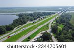 Jackson County Rest Area West rest area with Pascagoula River bridge, large parking lots semi-trucks, cargo trailers along Interstate 10 (I-10) floodplain in Gautier, Lower Mississippi. Aerial view