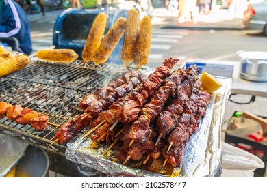 Jackson Heights, Queens, New York City, New York, USA. Meat Kebabs And Corn On The Cob At A Sidewalk Food Stand.