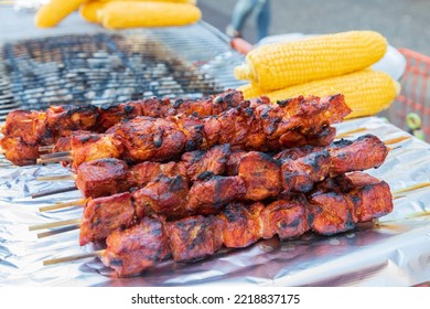 Jackson Heights, Queens, New York, USA. Meat Kebabs And Corn On The Cob At A Sidewalk Food Stand.