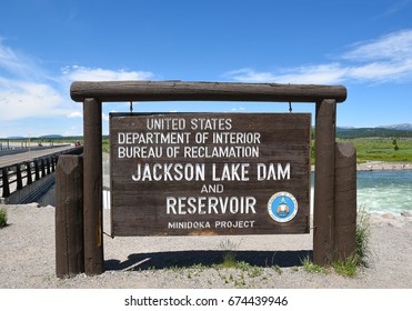 JACKSON HOLE, WYOMING - JUNE 26, 2017: Jackson Lake Dam Sign. Built In 1911 In Grand Teton National Park, It Has Enlarged The Natural Lake That Is Primarily Fed By The Snake River.