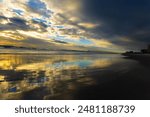 Jacksonville Beach sunrise: Golden rays streak over the Atlantic, painting the sky in pastel hues as waves whisper against the shore, welcoming a new day.