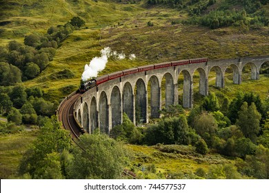 The Jacobite Steam Train Passing The Glenfinnan Viaduct In Scotland