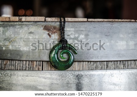 Jade Koru necklace over oak barrel