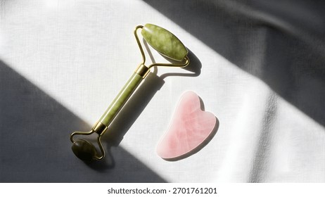 A jade roller and gua sha, tools for facial massage, are displayed on a white surface, promising a spa-like experience at home.