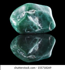 Jadeite mineral stone close up  with reflection on black surface background