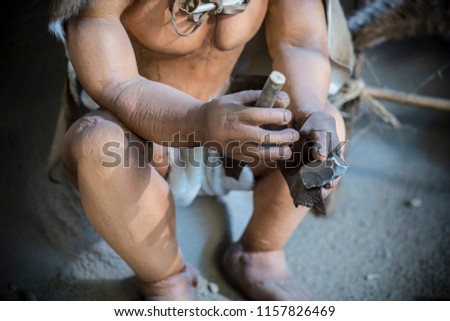 Jaen, Spain - December 29th, 2017: Life-sized sculpture of prehistoric man creating lithic tool at Jaen Museum