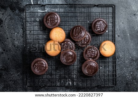 Jaffa Cakes, Cookies covered with dark chocolate and filled with orange marmalade. Black background. Top view.