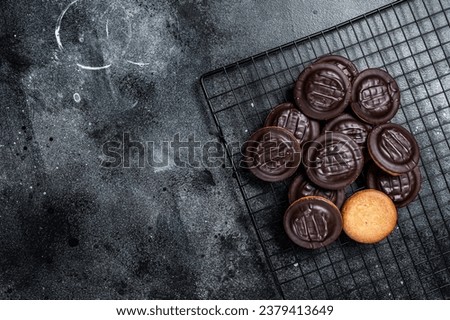Jaffa Cakes, Cookies covered with dark chocolate and filled with orange marmalade. Black background. Top view. Copy space.
