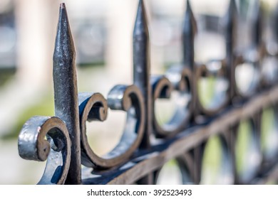 Jagged iron fence with blurry background