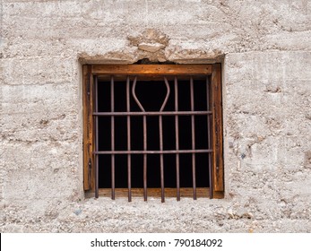 Jail Window With Bent Rusty Bars In Crude Concrete Wall