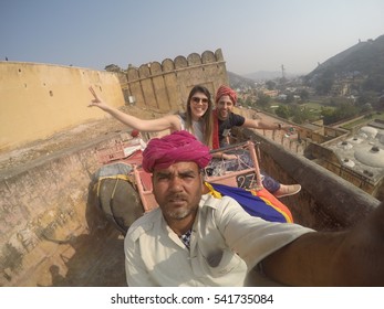 JAIPIR, INDIA - CIRCA NOVEMBER 2016: Couple Talking A Selfie With A Local In Elephant In Amber Fort, Jaipur, India - With Gopro Camera