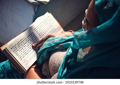 Jaipur, India - 02 12 2020: Old Woman Reads The Holy Book Of Hindu Pilgrims Gita