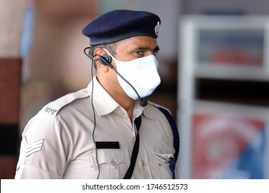 Jaipur,Rajasthan,India_May-2020. Corona Warrior Cop At Work At Jaipur Railway Station,India. Masked Cop Wearing Gadgets Of Mass Communication. Headphone. Cops Helping The Movement Of Migrant Workers.