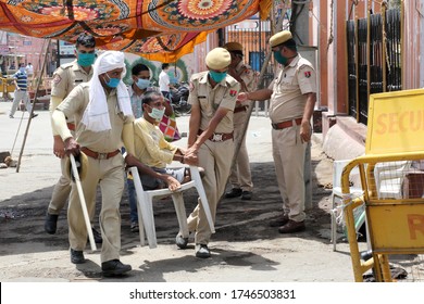 Jaipur,Rajasthan,India_May-2020. Corona Warrior Cops Helping A Disabled Person At Jaipur Railway Station,India. Masked Cop Carrying Disabled Person On Chair To Board Train.No Wheelchair For Disabled. 