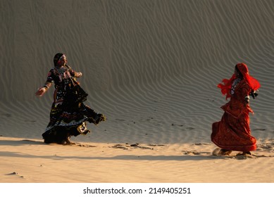 Jaisalmer Rajasthan India Asia Oct. 09 2006 Blurred image Rajasthani girls in traditional outfits dancing traditional folk dance in sand dunes