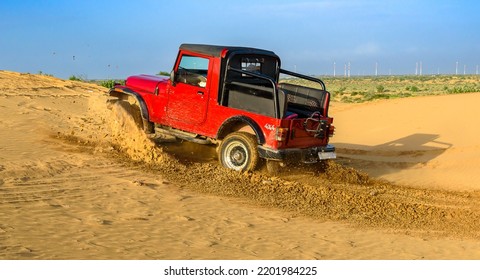 Jaisalmer , Rajasthan, India, August 25 2022:  Red Suv Doing Drift In Rajasthan Jaisalmer Desert, India. 