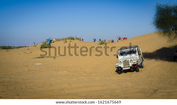 JAISALMER, RAJASTHAN, INDIA- DECEMBER\
2019: Desert Jeep Safari on the sand dunes. Jeep safaris in the\
Thar desert has become very popular in last few years.\

