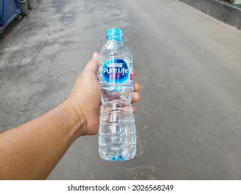 Jakarta August 2021-an Adult's Hand Holding A Bottle Of Bottled Water With The Trademark Pure Life From One Of The Bottled Water Companies In Indonesia 