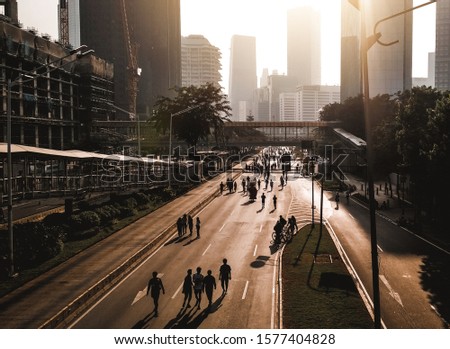 Jakarta in early morning. Shadows and silhouettes of people at a city during Car free day.