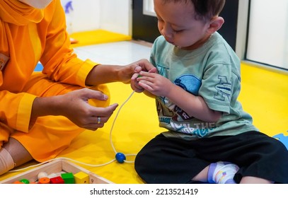 Jakarta, Indonesia 12th 2022 : Child Occupational Therapy Session. Male Children Doing Playful Exercises With His Therapist.