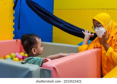 Jakarta, Indonesia 12th 2022 : Child Occupational Therapy Session. Male Children Doing Playful Exercises With His Therapist.