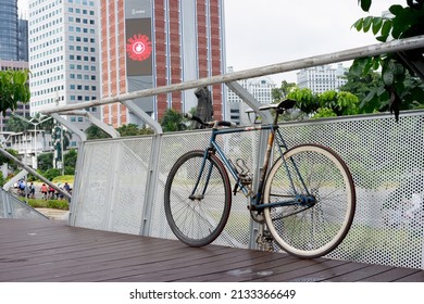 Jakarta, Indonesia, 14 February 2021: a fixie bike leaning against a fence near Sudirman Street in the middle of Jakarta