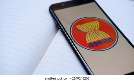 Jakarta, Indonesia - April 25, 2022: ASEAN Logo And Symbol On Smartphone With Book Background 