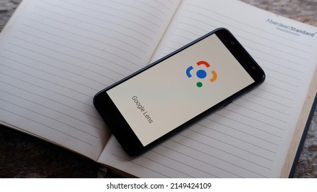 Jakarta, Indonesia - April 25, 2022: A smartphone with Google lens application on book background 